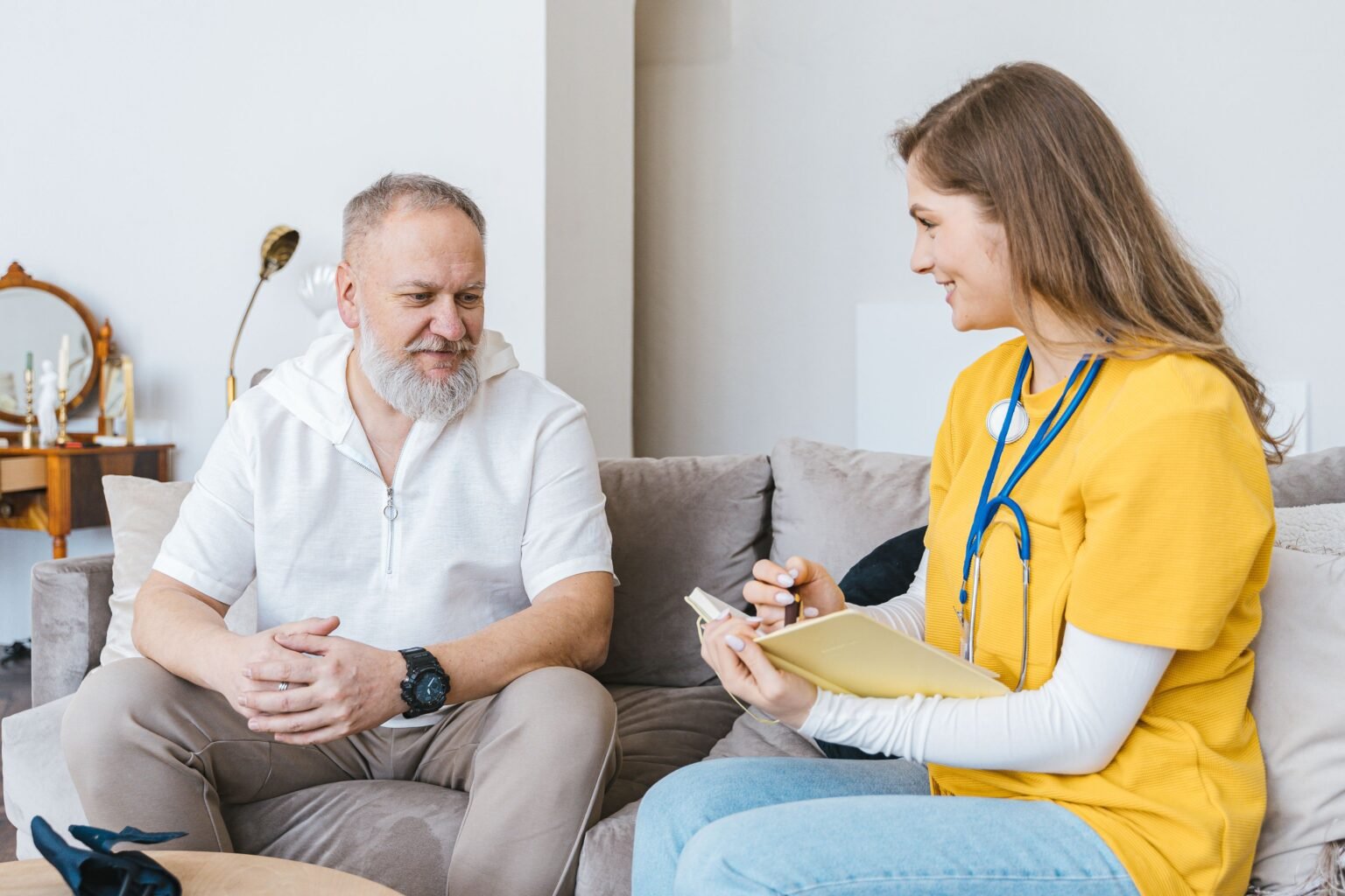 Professionnelle de santé avec stethoscope consultant un patient a domicile dans le cadre d'une hospitalisation a domicile