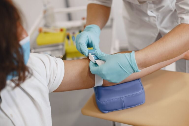 Infirmier posant un garrot au bras d'un patient avant une prise de sang à domicile