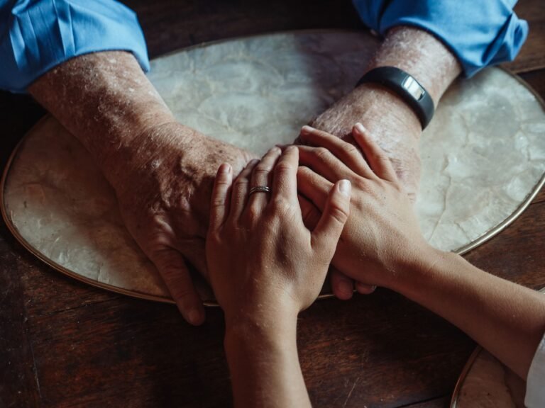 Mains de deux générations unies, symbole de l'accompagnement d'un proche en soins palliatifs à domicile