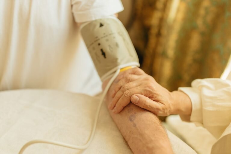 Professionnel de santé mesurant la tension artérielle d'une personne âgée lors d'un bilan prévention à domicile